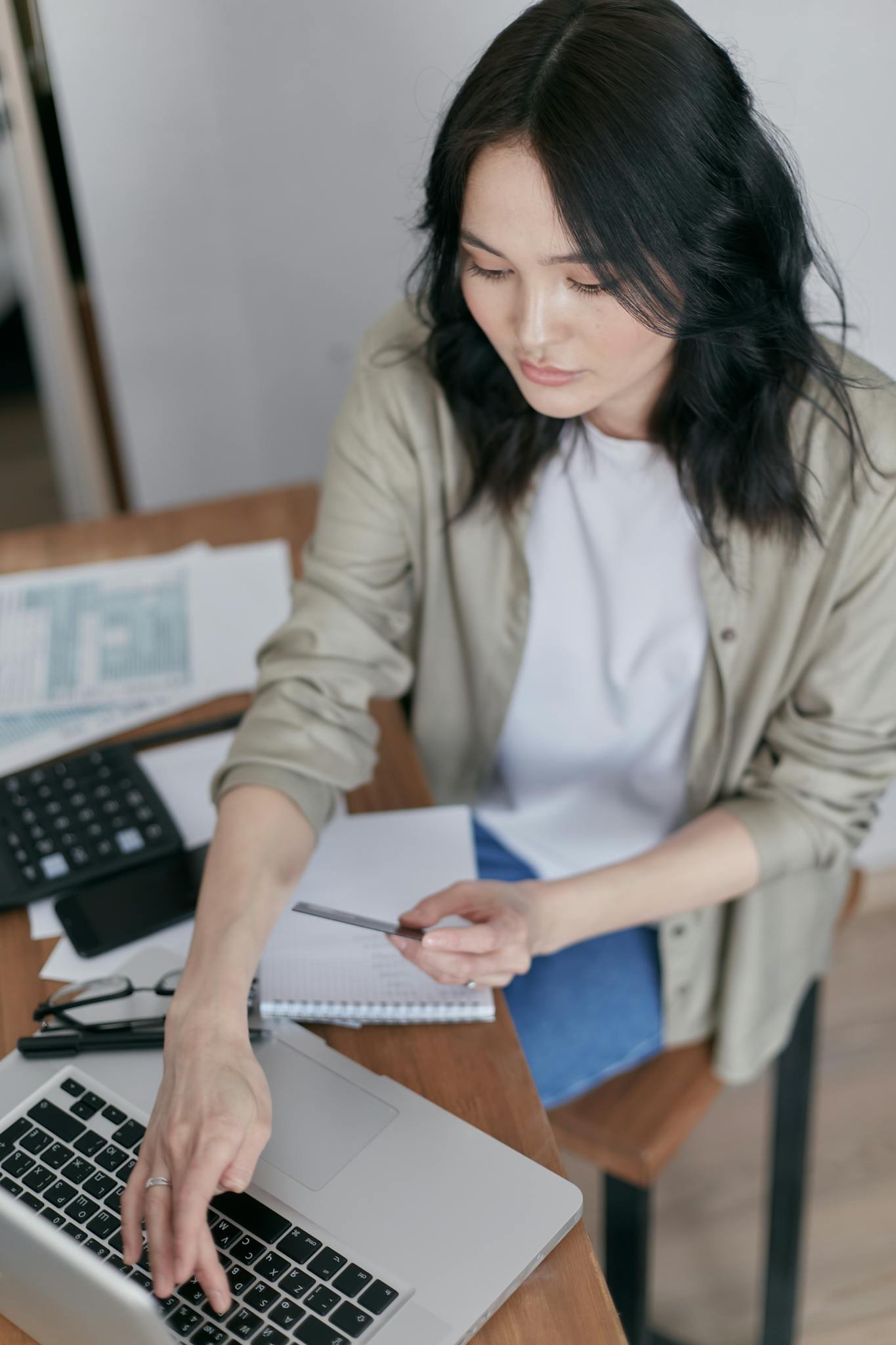 A Woman Sitting at a Wooden Desk Using a Laptop